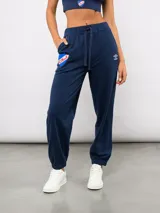 Pantalón de piqué recto color azul marino, con cintura elástica y cordón ajustable. Presenta el escudo del Club Nacional de Football en el muslo izquierdo y el logo de Umbro en el muslo derecho.