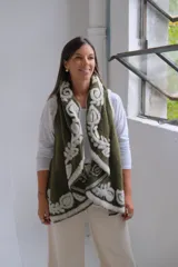 Chaleco abierto de tejido de punto color verde oliva, con bordes decorados con un diseño floral en relieve de color blanco. Presenta una caída fluida y un estilo envolvente.