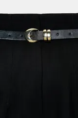 Pantalón de tiro alto y corte tobillero, confeccionado en tejido de aspecto denim oscuro. Presenta diseño de pinzas frontales, bolsillos laterales y cierre frontal con cremallera, botón y gancho. Incluye un cinturón fino a tono con hebilla metálica dorada.