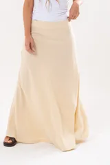 Pollera larga de corte recto en color amarillo pálido, con sutil textura en relieve y diseño fluido hasta los tobillos.