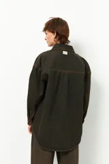 Camisa de jean celeste de manga larga con botones marrones.