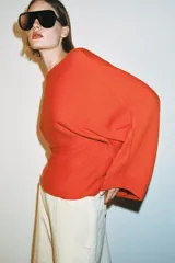 Jersey de punto con cuello barco y mangas anchas tipo murciélago, de diseño holgado y fluido.
