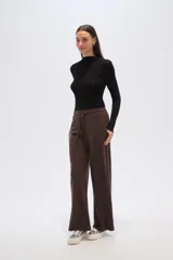 Pantalon de corte holgado y tiro alto, confeccionado en tejido de poliester con textura acanalada. Presenta cintura elástica con cordón de ajuste y diseño de pierna ancha.