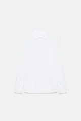 Camisa blanca de algodón con cuello solapa, manga larga y cierre frontal de botones.