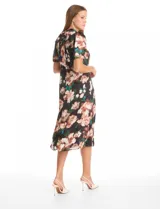 Vestido midi de satén con estampado floral sobre fondo negro. Presenta cuello a la base con frunce, mangas cortas abullonadas con terminación elástica, cintura definida y un tajo lateral pronunciado. Incluye forro interno y lazo posterior para ajustar el cuello.