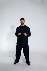 Pantalón sastrero de corte recto y tiro alto, confeccionado en lycra de color negro. Presenta cierre frontal con botón, bolsillos laterales y un diseño que combina la estructura de la sastrería con la comodidad de un tejido elástico.