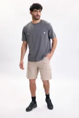 Bermuda cargo color taupe, de corte recto y holgado, con bolsillos laterales con solapa y cierre de botones.