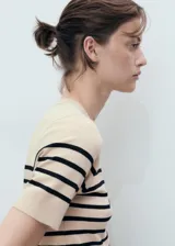 Jersey de punto fino beige con rayas horizontales negras, cuello redondo y manga corta.