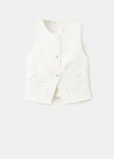 Chaleco recto color blanco de soft denim, con cuello redondo y cierre frontal de botones. Presenta delicados bordados florales calados en toda la prenda.
