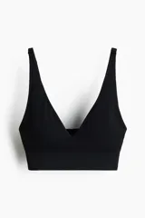 Soutien suave de punto seamless color negro, con escote en V profundo, tirantes ajustables y banda elástica ancha en la base para mayor sujeción.