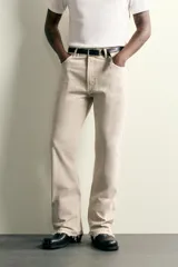 Jeans flare fit de tiro medio confeccionados en denim de algodón color beige, con cinco bolsillos, efecto salpicaduras y bajo irregular.