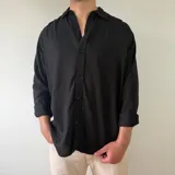 Camisa de lino de manga larga, color negro, con cuello camisero clásico y cierre frontal de botones.