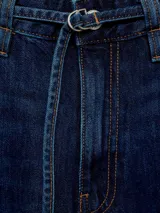 Pantalón de jean estilo wide leg, de tiro medio y color azul oscuro. Cuenta con cierre frontal de cremallera y botón, cinco bolsillos y trabillas para cinturón.