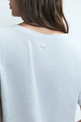 Pijama compuesto por una remera gris de manga corta con estampa frontal de corazón y un pantalón largo blanco con estampado de corazones rojos.