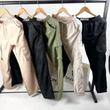 Pantalón cargo verde de nylon, corte holgado con bolsillos laterales y cintura elástica ajustable con cordón.