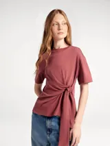 Blusa de algodón color beige, con cuello redondo, mangas cortas y detalle de lazo lateral que genera un efecto drapeado en la cintura.