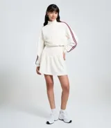 Short pollera corto de malla waffle color blanco, con cintura ancha en V y cierre de cremallera en la espalda. Presenta rayas contrastantes en los laterales.