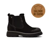 Bota tipo chelsea de cuero negro con costuras blancas a la vista, paneles elásticos laterales y suela track de goma robusta.