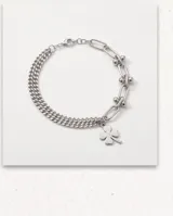 Pulsera de plata con diseño de cadena múltiple y dije colgante en forma de trébol de cuatro hojas.