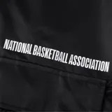 Campera negra con capucha y cierre frontal. Tiene un bolsillo de red en el pecho y el logo de la NBA en la manga.