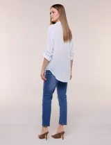 Camisa de calce holgado en género liviano con estampado a rayas verticales, cuello camisero clásico y abotonadura frontal a tono. Presenta mangas largas regulables con presilla y botón para ajustar a tres cuartos, espalda con canesú y suave pliegue central, y ruedo curvo estilo camisero.