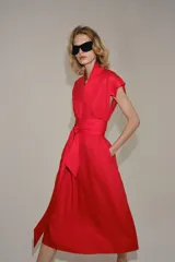 Vestido midi rojo de la colección ZW de Zara, confeccionado en hilatura con lino. Cuenta con escote en pico, manga corta, bolsillos laterales ocultos en la costura, falda de corte evasé y cierre frontal con cinturón ajustable del mismo tejido.