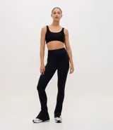 Pantalón deportivo tipo legging flare de tiro alto, confeccionado en microfibra con abertura lateral en el ruedo.