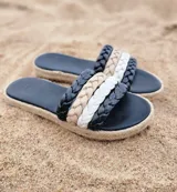 Sandalias chatas color nude con tiras trenzadas y suela de yute.