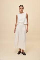 Top sin mangas color blanco con escote redondo, calce amplio y diseño con bordado floral en relieve.