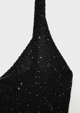 Vestido midi de punto con lentejuelas brillantes, escote en pico y tirantes finos. Diseño entallado con abertura frontal.