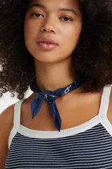 Musculosa a rayas horizontales azul marino y blancas, con breteles anchos y cuello redondo con ribete blanco.