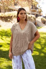 Chaleco de punto color beige, con escote en V y diseño holgado sin mangas.