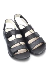 Sandalias amarillas de cuero con tres tiras con cierre de velcro y suela blanca.