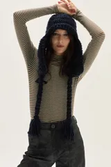 Polera de manga larga con cuello alto, confeccionada en tejido de punto acanalado con diseño de rayas horizontales en color marrón y turquesa. Presenta un bordado pequeño en el pecho y un calce ajustado al cuerpo.