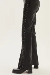 Jean de corte bootcut color negro lavado, con acordonado lateral completo en ambos lados.