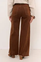 Jean de corte wide leg y tiro medio, con diseño de perneras amplias y terminación desmechada en el bajo.