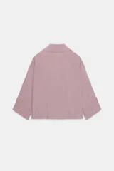 Chaqueta corta marrón de cuello solapa y manga remangada por debajo del codo. Presenta bolsillos delanteros de plastrón con solapa, bajo ajustable con cordón interior y cierre frontal con botones.
