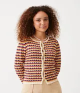 Chaqueta de punto de manga larga, cuello redondo y cierre frontal con botones de madera. Presenta un patrón de rayas horizontales en zigzag con colores crema, mostaza, fucsia y morado.