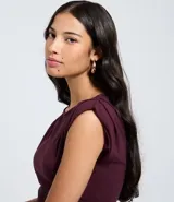 Top ajustado color rojo, con cuello redondo y mangas cortas tipo hombreras o almohadillas. El tejido parece ser de punto o viscosa con buena caída y presenta un fruncido horizontal a la altura de la cintura.