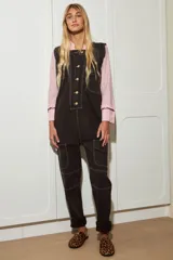 Enterito de jean color chocolate, con botones delanteros, bolsillos laterales y pespunte blanco.