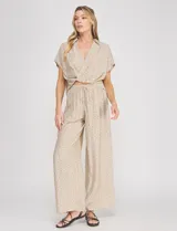 Palazzo de tiro alto color beige con estampado de lunares, cintura elastizada con cordón de ajuste y corte de pierna ancho.