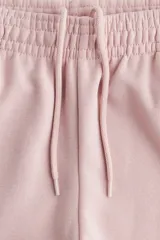 Pantalón de jogging de corte ancho y tiro alto, confeccionado en tejido de felpa con interior cepillado suave. Presenta cintura elástica fruncida con cordón de ajuste oculto, bolsillos laterales discretos y un bolsillo trasero abierto.