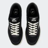 Championes New Balance 440 de estilo skate, color negro con detalles en blanco, pasacordones y suela de goma color miel.