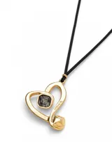 Colgante largo con cordón negro efecto seda y dije de corazón dorado con cristal negro en el centro.