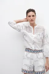 Short de tiro alto color blanco con estampado de palmeras y aves en tonos grises y azules.