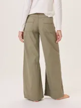 Pantalon de corte ancho y holgado, confeccionado en mezcla de algodón, viscosa y lino. Presenta costuras decorativas, pinzas debajo de la rodilla, bordado de monograma en el bolsillo delantero y pespuntes a contratono.