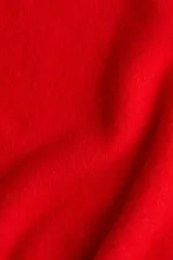 Chaleco corto de punto rojo vibrante, con cuello camisero y tapeta de tres botones oscuros. Presenta un tejido suave y ligeramente texturado, con ribetes acanalados en las sisas y el bajo.