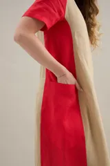 Vestido largo de lino con diseño bicolor en tonos lila y gris claro, escote redondo, mangas cortas y silueta relajada con bolsillos laterales.