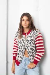 Saco de punto con diseño combinado, presentando un estampado de animal print en el frente y mangas a rayas horizontales en rojo y beige. Posee cuello redondo, cierre frontal con botones y terminaciones en tejido acanalado de color rojo.