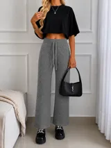 Pantalón de lanilla color beige con sutiles destellos brillantes, de corte recto y holgado. Cuenta con cintura elástica con cordón ajustable.